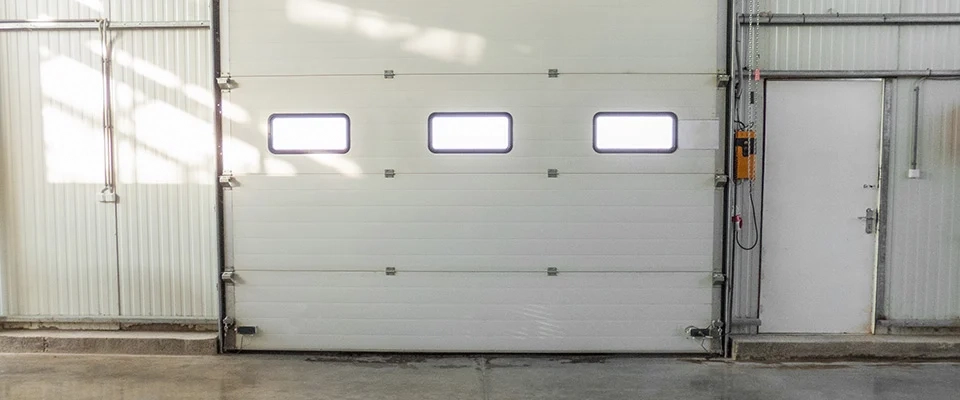 A white rolling gate that can be upgraded with an intelligent IoT gate control system.